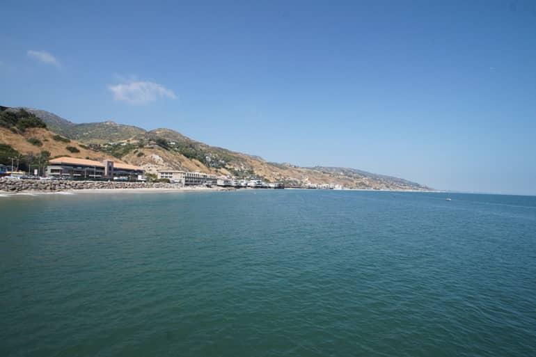 A cove in Malibu, Los Angeles - USA, with beach and blue water.