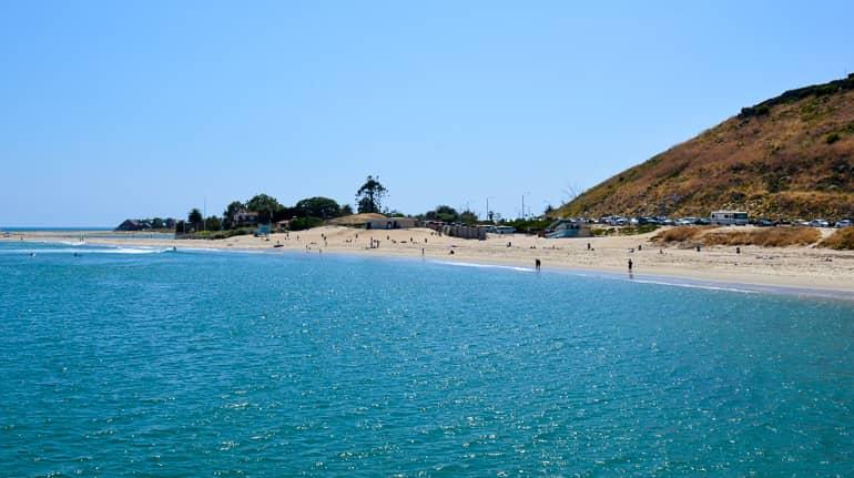 The blue water sparkles in the sun at Santa Monica Malibu Beach, beachgoers are enjoying the fine sandy beach.