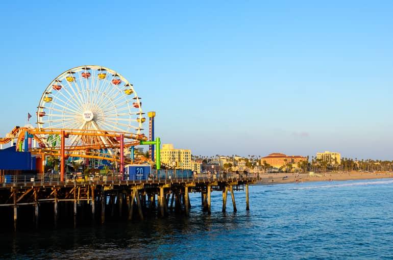 In the evening sun at Santa Monica Malibu Pier, a Ferris wheel rises skyward at the beach.