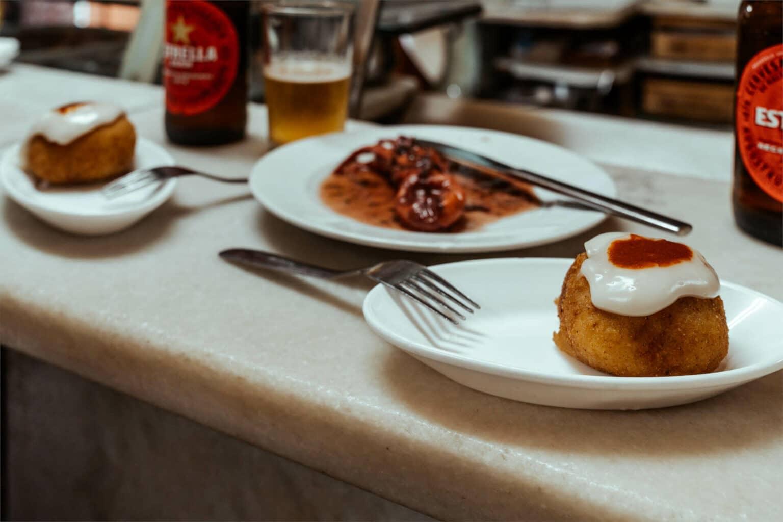 En el barrio de pescadores Barceloneta en Barcelona, asegúrate de probar las alcachofas a la parrilla y el pulpo en la taberna La Cova Fumada.