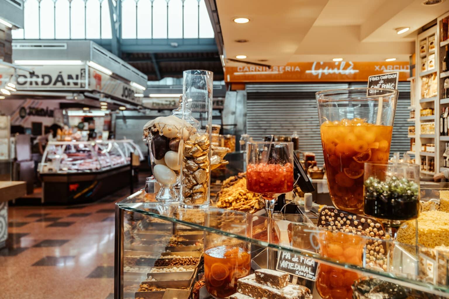 Barra en el Mercat Llibertat con vista a la vitrina repleta de delicias