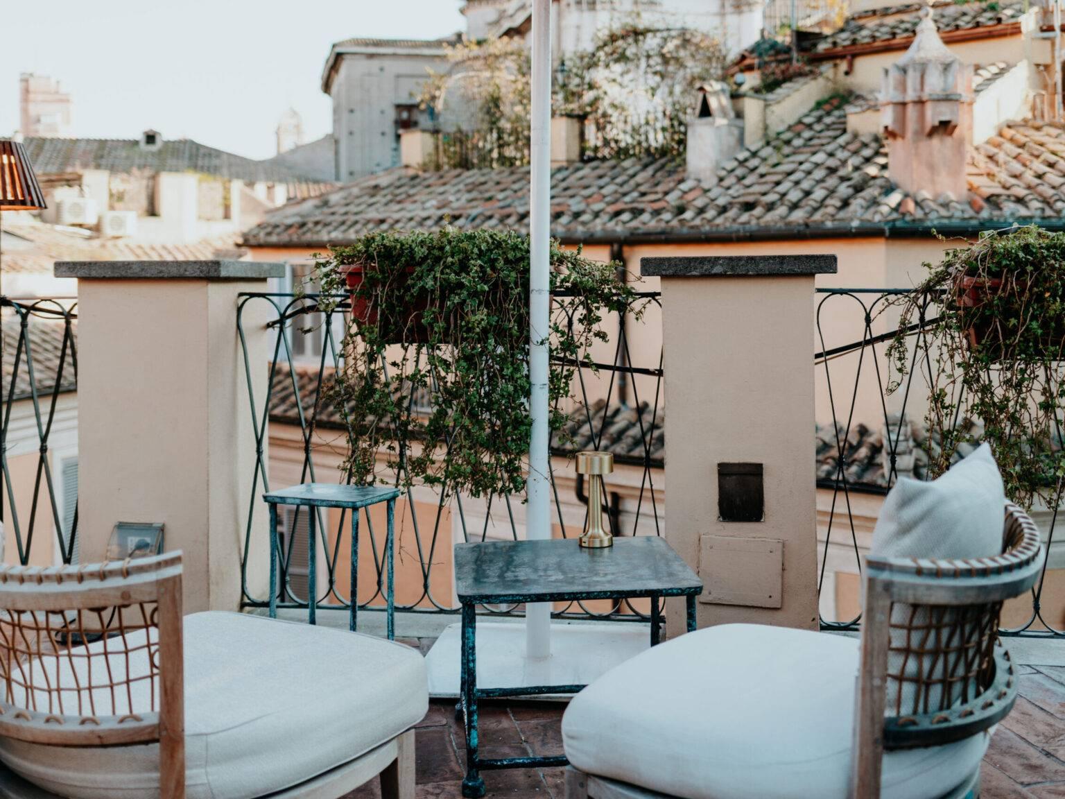 Cozy rooftop terrace of the Hotel Cesàri in Rome with a view of tiled roofs and seating.