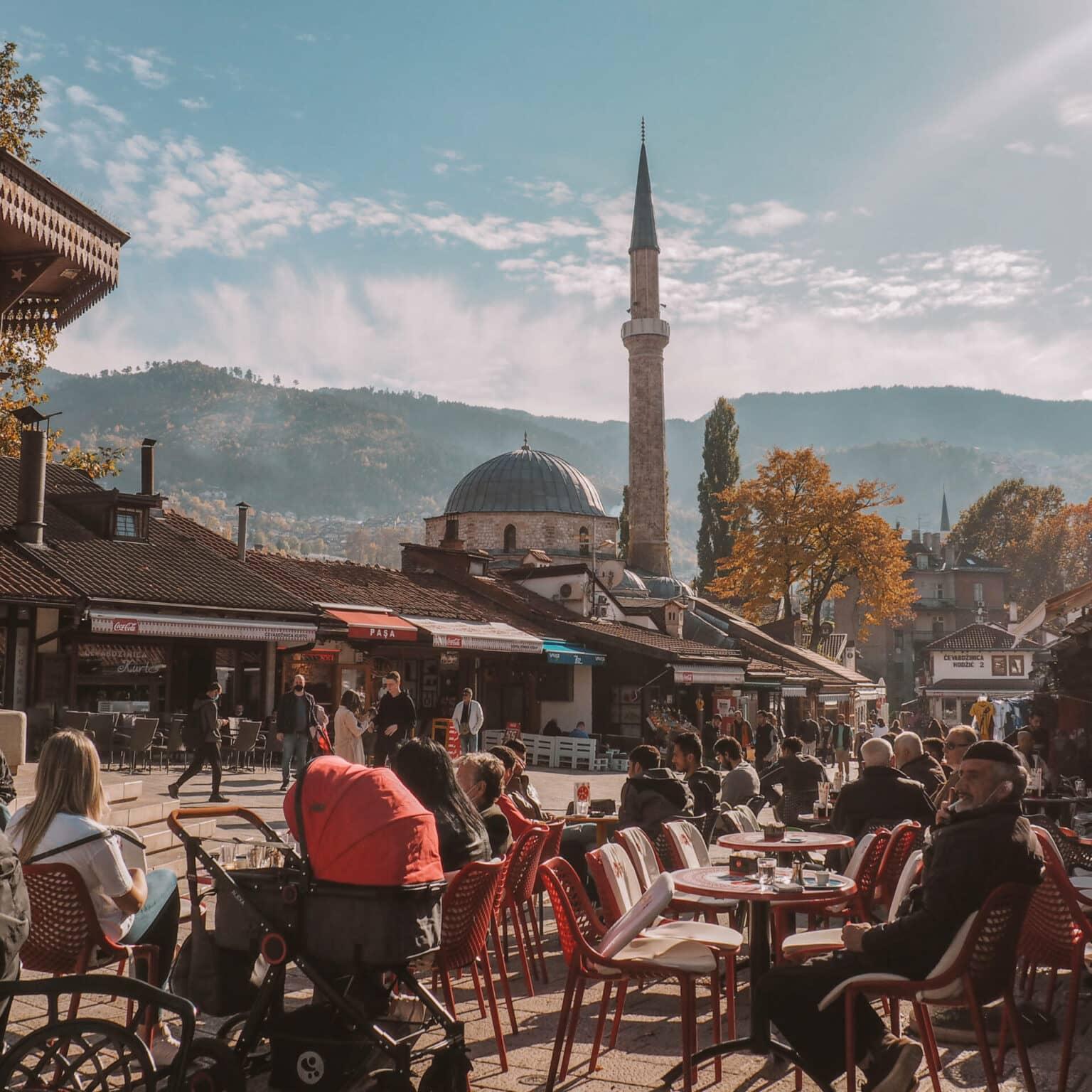 Locales y turistas disfrutan del sol en una plaza del casco antiguo de Sarajevo.