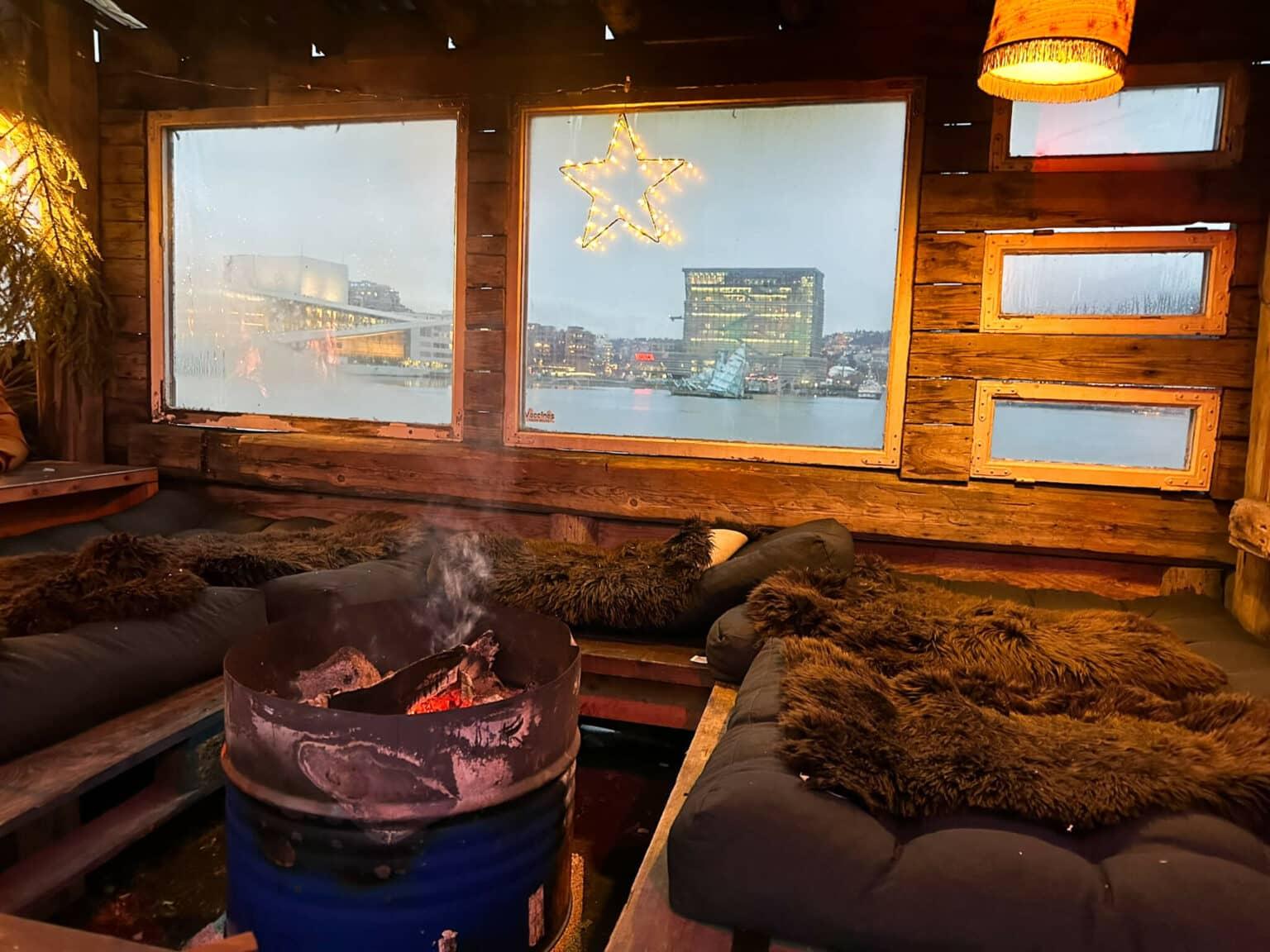 A cozy seating area with furs and a fire at the Salt Christmas market in Oslo