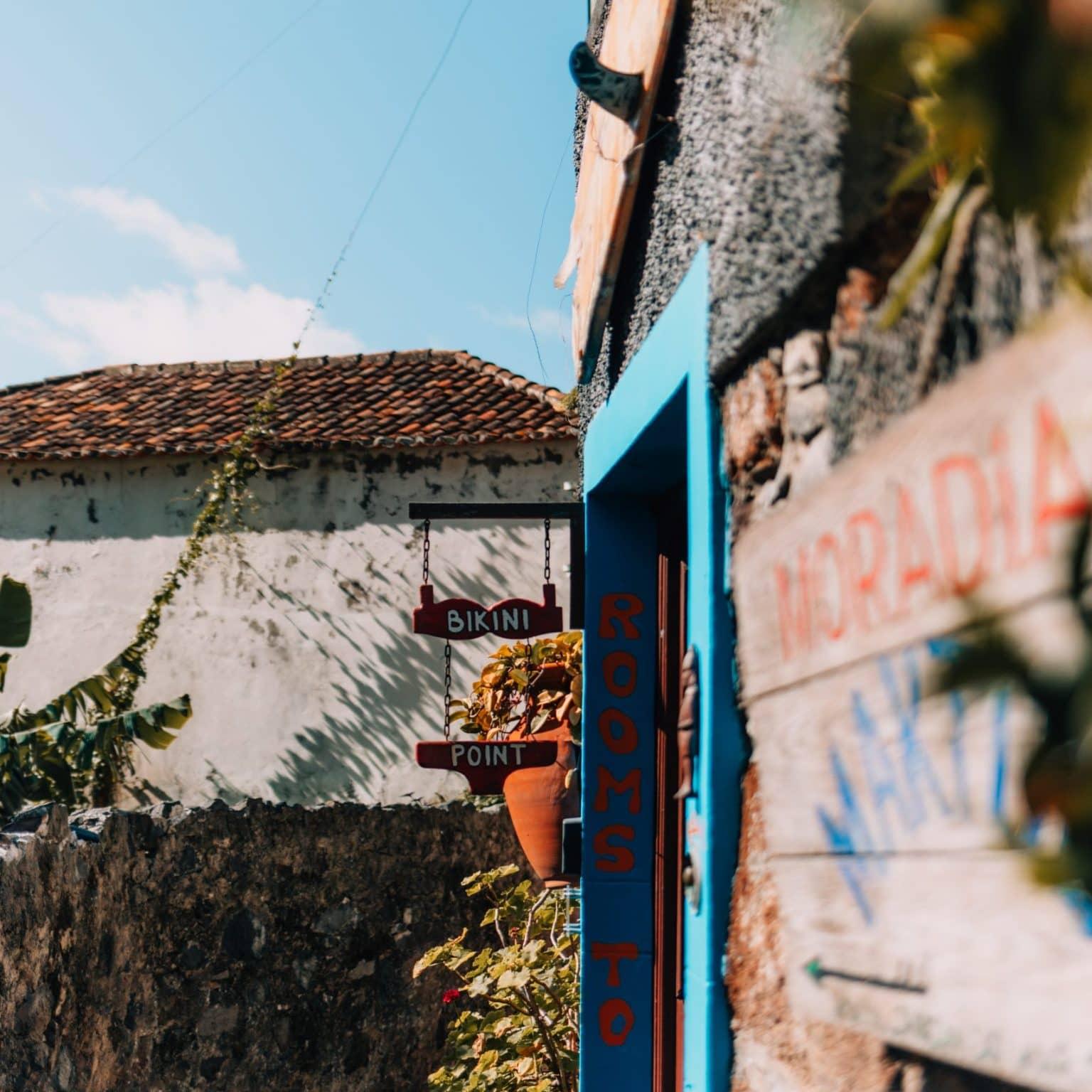 An idyllic little guesthouse with a hanging sign under a blue sky.