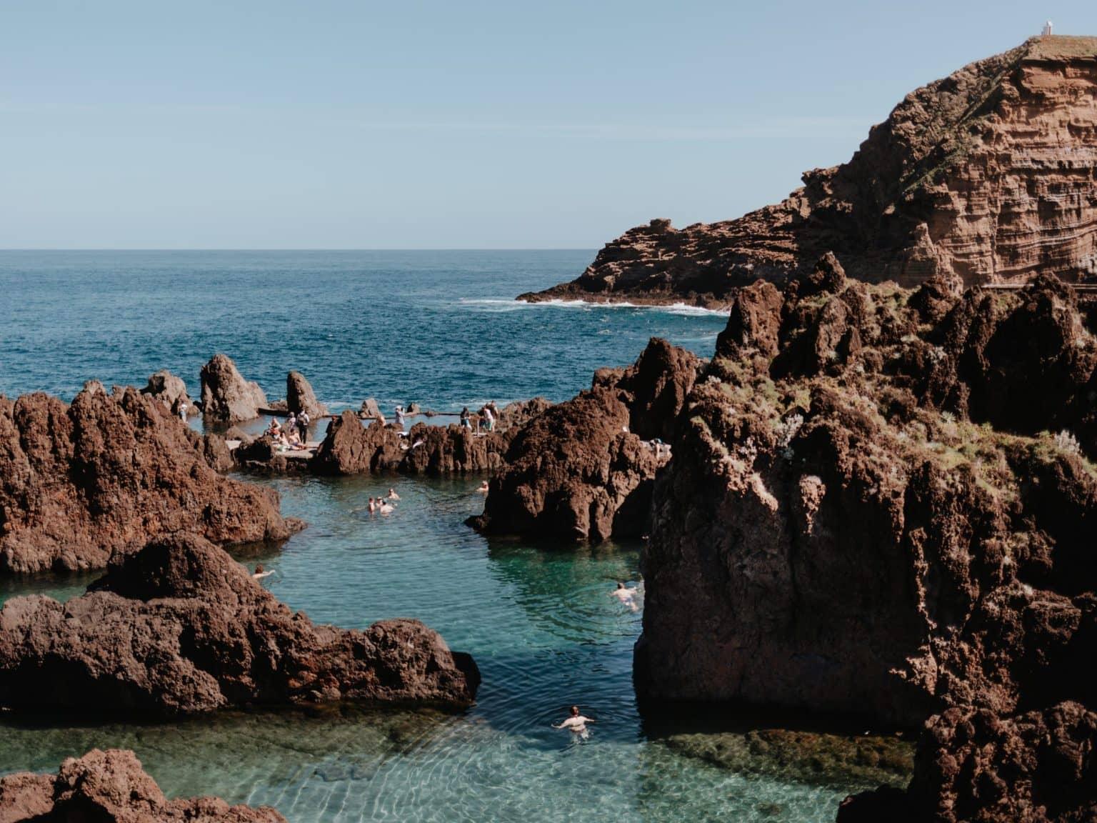 Many rocks in the water form small, natural swimming pools with little wave action.