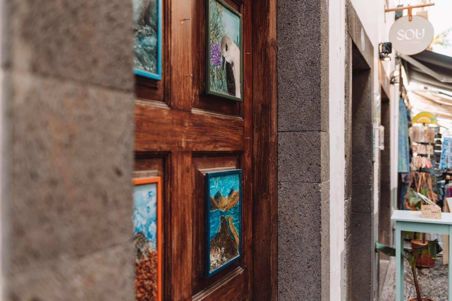 A wooden door at a market adorned with lovingly painted wooden panels.
