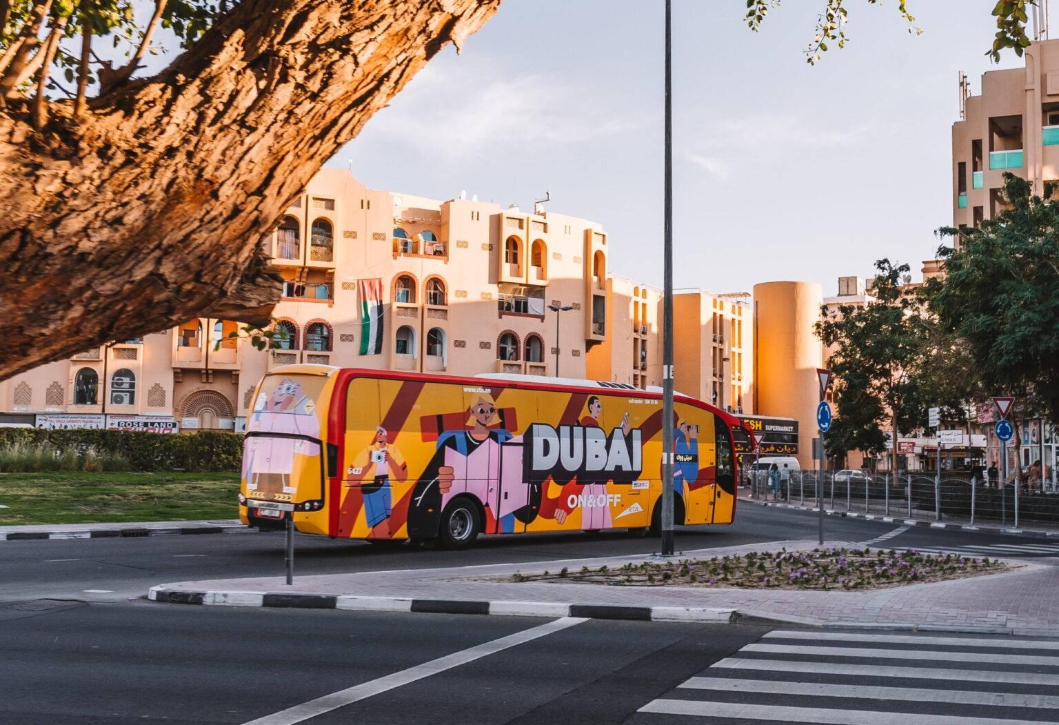 Un autobús RTA de colorido diseño pasa por una calle.