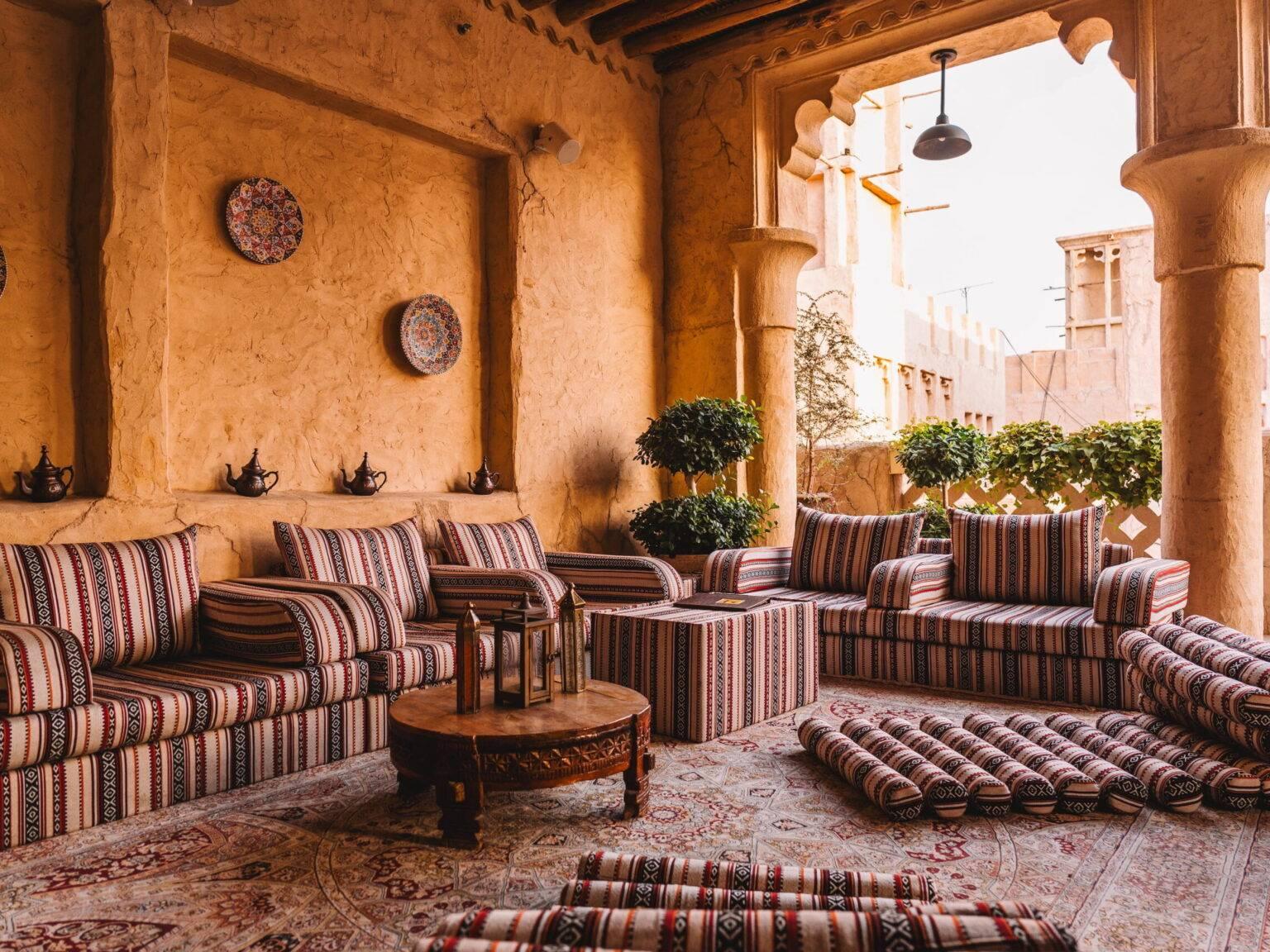 Una zona de estar semiabierta con cojines de colores en el Al Seef Heritage Hotel.