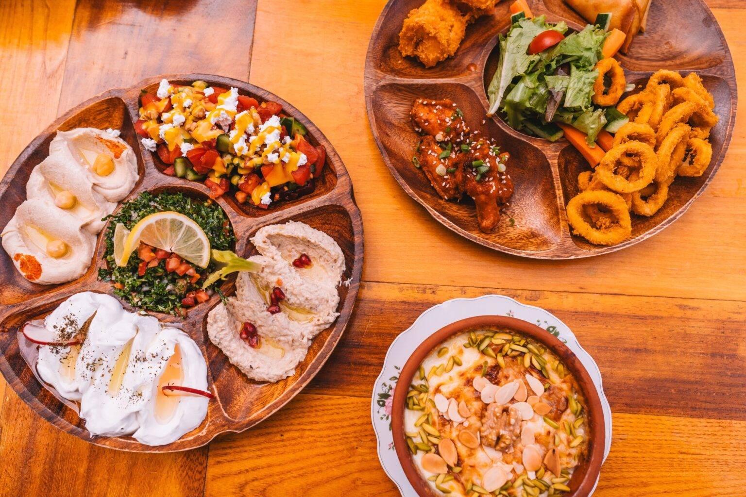 Tres platos con diferentes dips y comidas árabes.