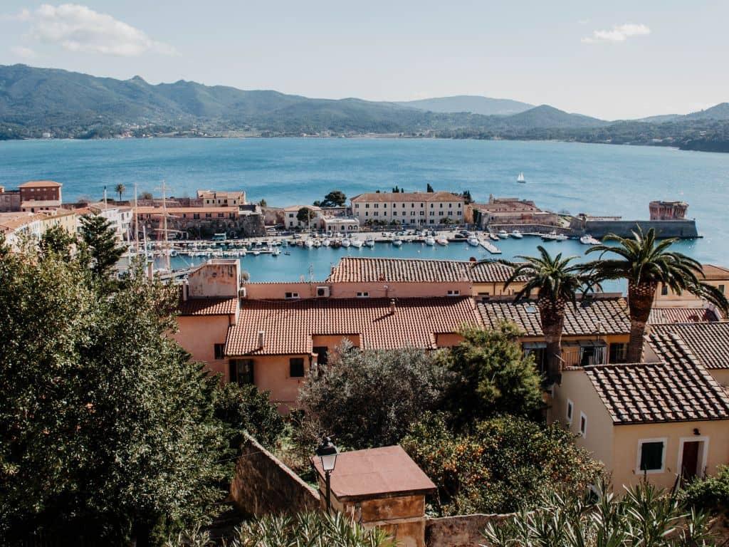 Desde la fortaleza en Portoferraio, los visitantes de la isla de Elba tienen una maravillosa vista sobre los techos de las casas y las palmeras hacia el puerto deportivo, que vale la pena visitar. Al fondo se levantan las montañas de la pequeña isla toscana.