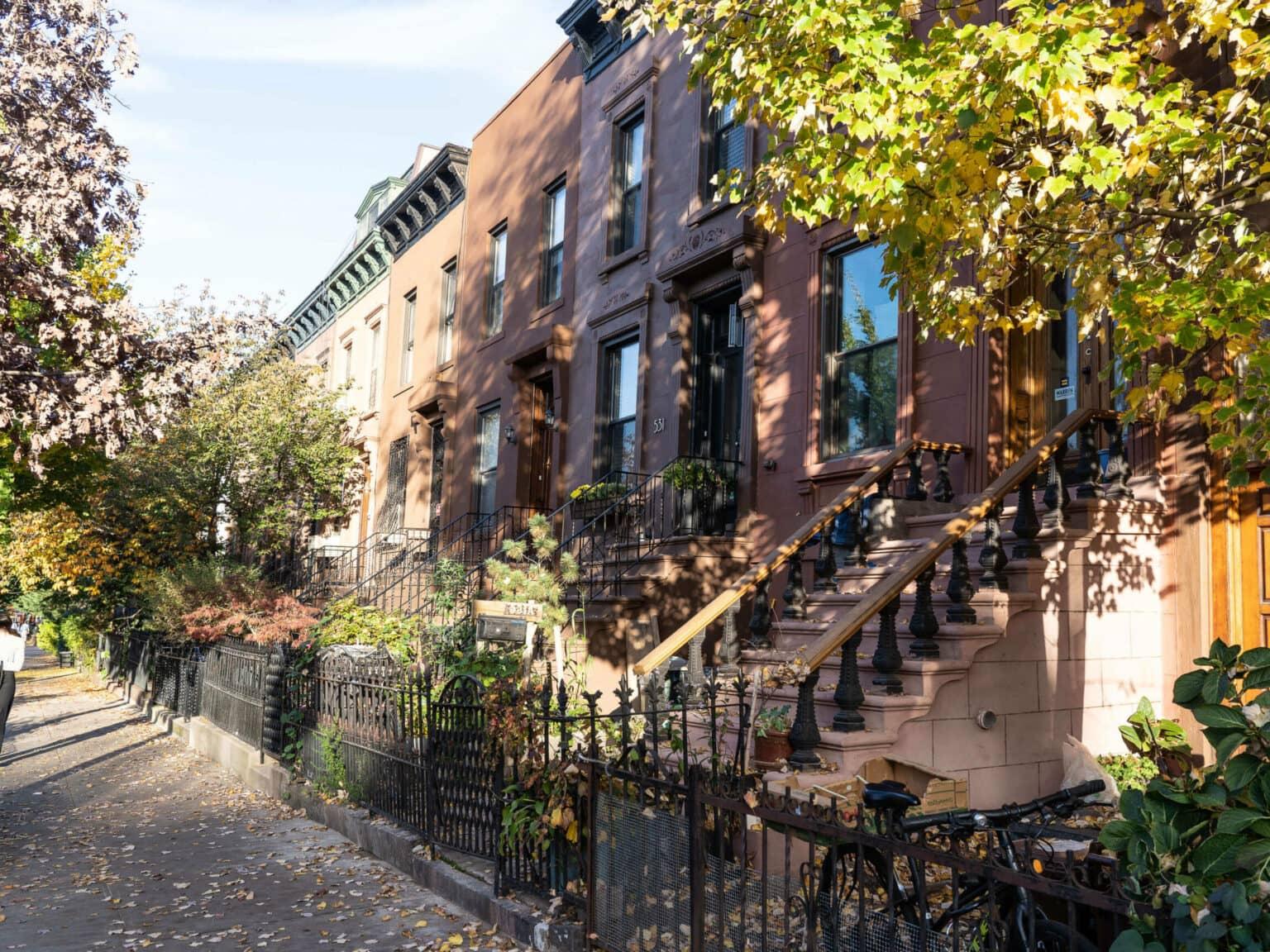 Brownstone houses, a landmark of Brooklyn, are row houses in various shades of brown with small gardens and stairs leading up to the front doors.