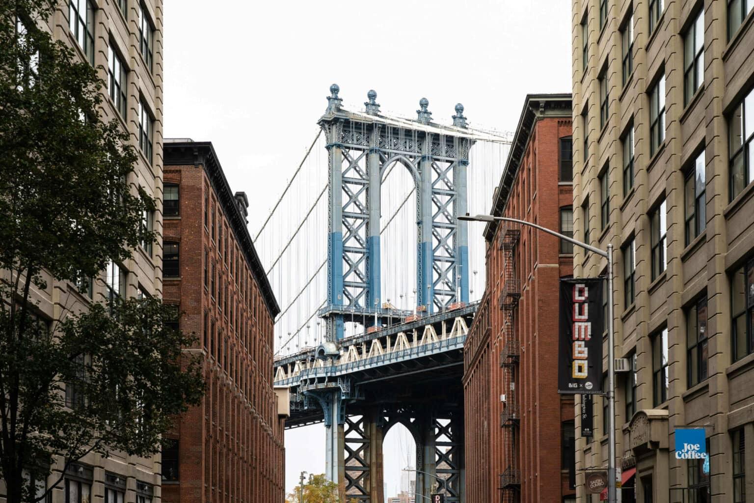 View through houses to the Manhattan Bridge from the Washington Street Viewpoint in Dumbo, a neighborhood in Brooklyn, New York.