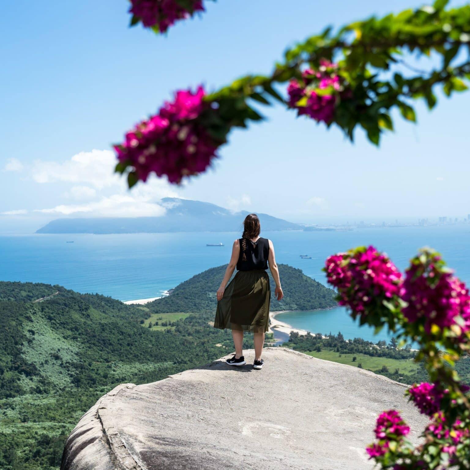 A rider on a rock with a view of the sea at the Hai Van Pass.