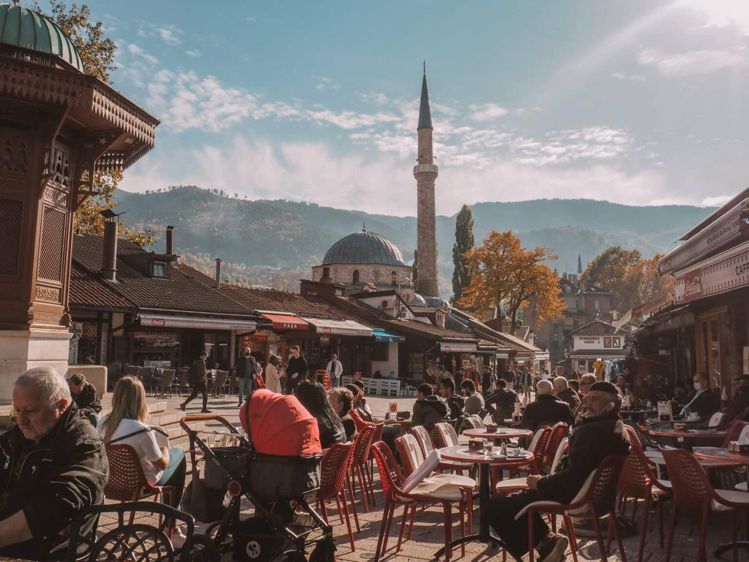 Locals and tourists enjoy the sun in a square in Sarajevo's Old Town.
