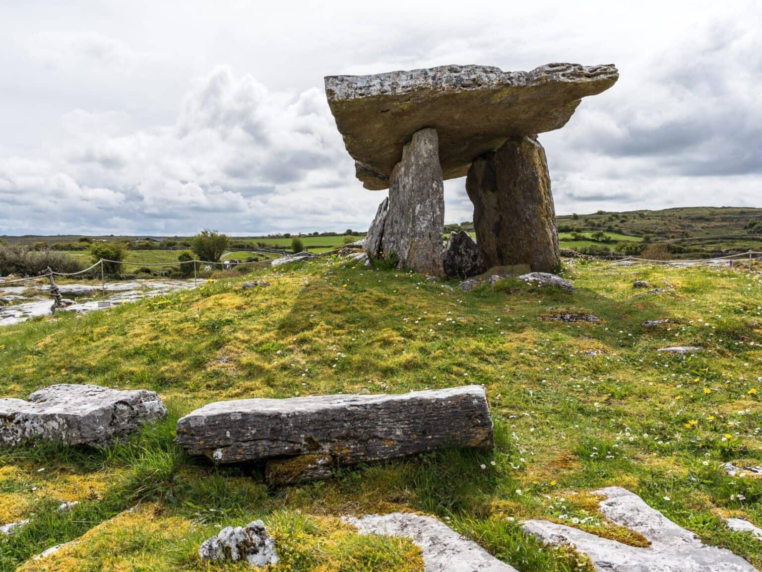 A prehistoric tomb - stacked stones on a lush green meadow.