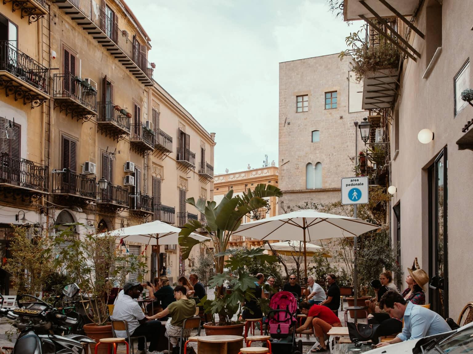 A small square in Palermo, people sitting in a cafe.