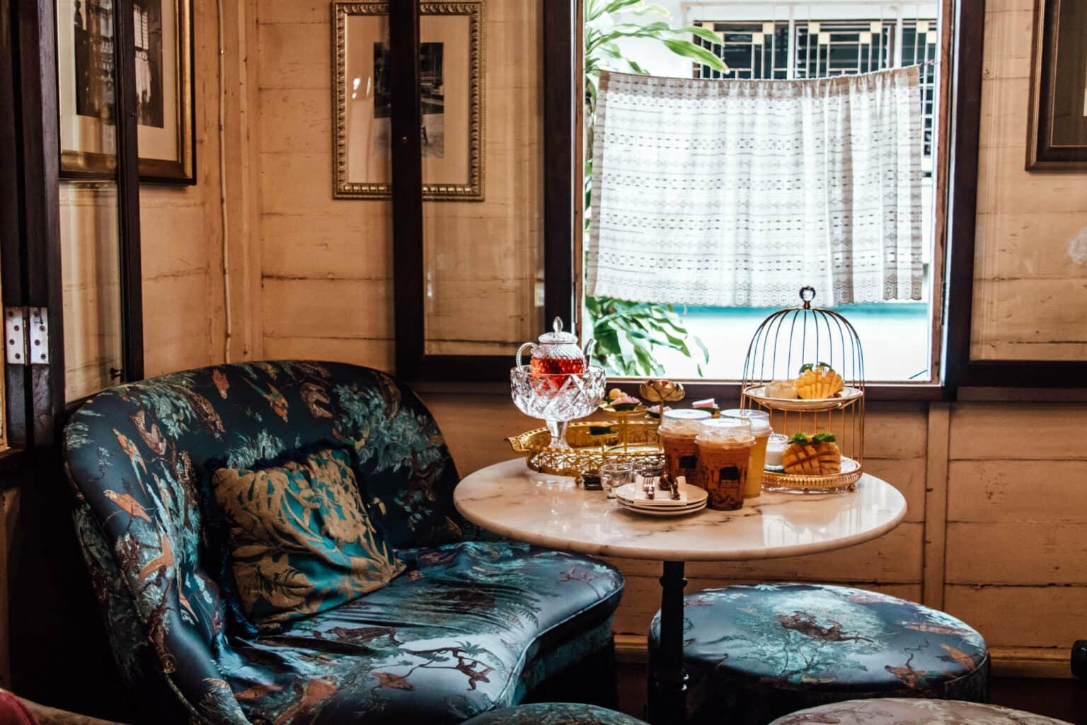 A table in the Gingerbread House featuring Thai tea specialties surrounded by teal-colored furniture.