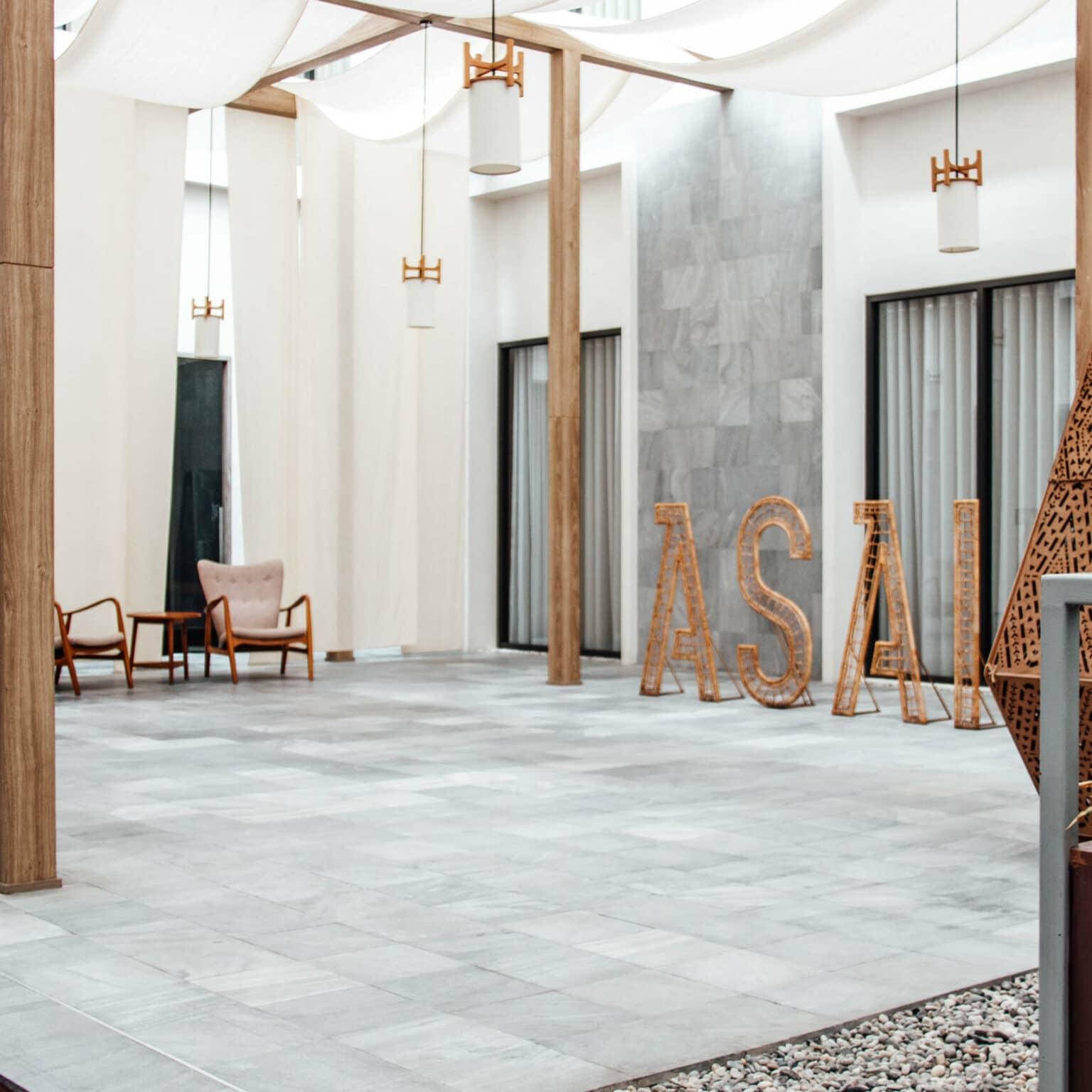 The modern ASAI Hotel in Chinatown, Bangkok, with gray walls and white cloths hanging from the ceiling.