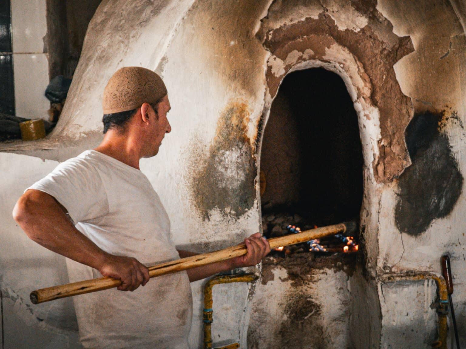 A baker at the Chorsu Bazaar in Tashkent traditional baking bread in a clay oven