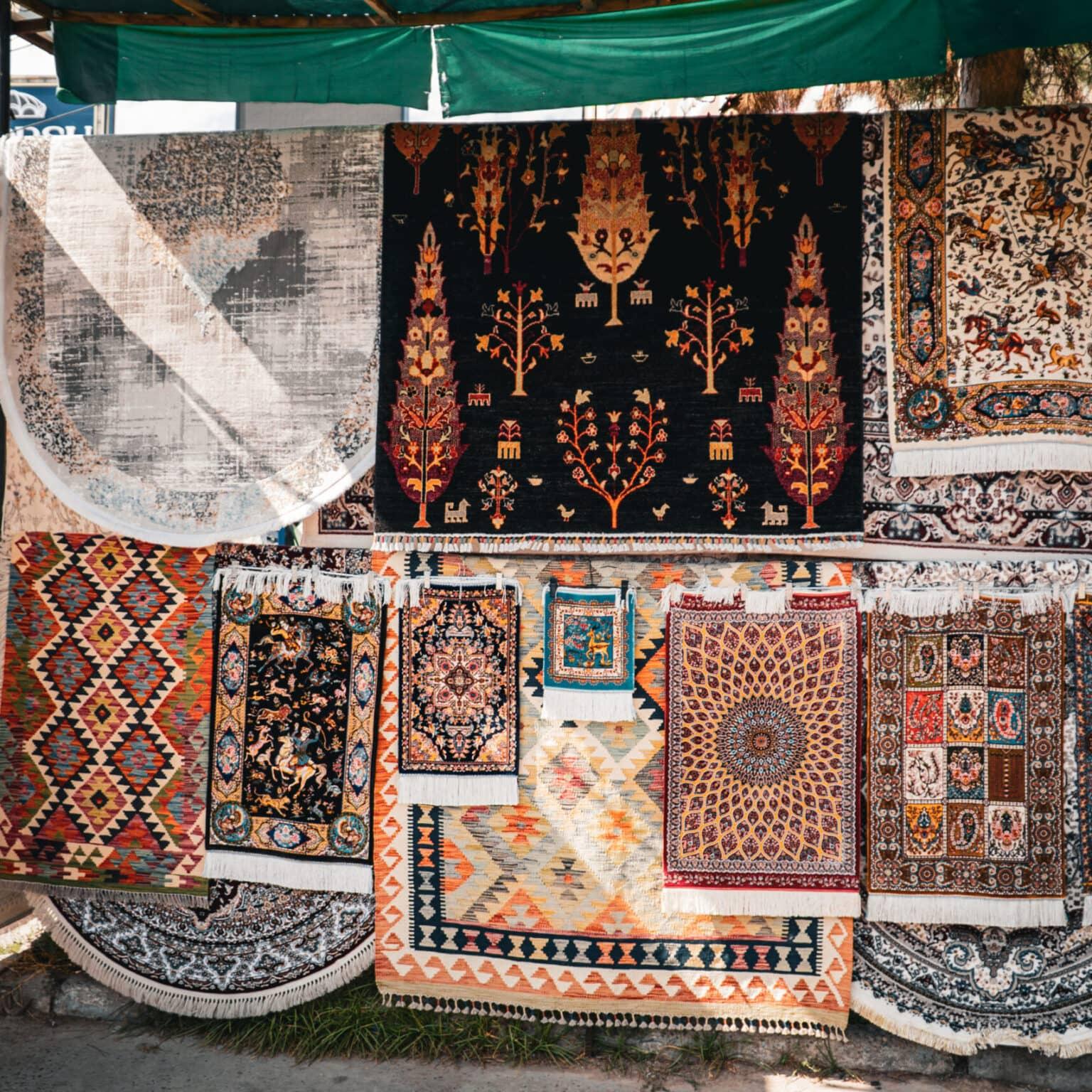 Traditional carpets in various patterns and colors displayed at the Chorsu Bazaar in Tashkent