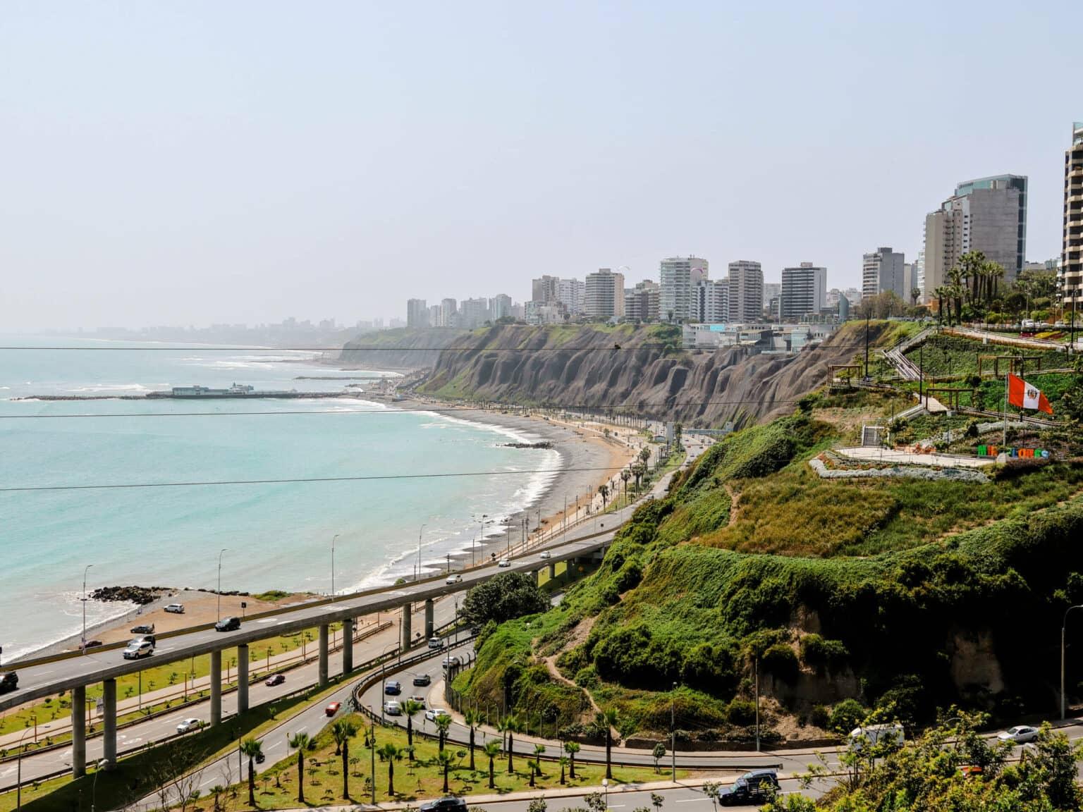 A long coastline with beaches, roads, and green hills stretches in Lima.
