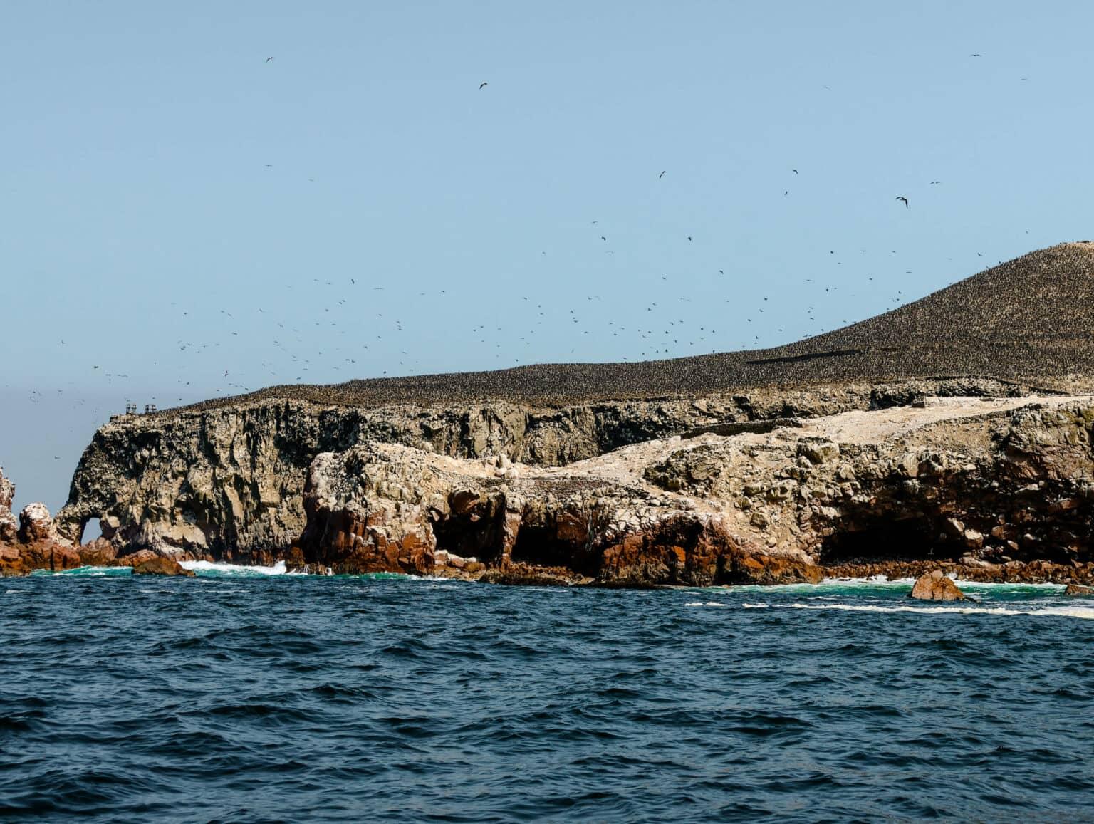The blue sea in front of a rocky coast of the Ballestas Islands in Lima.