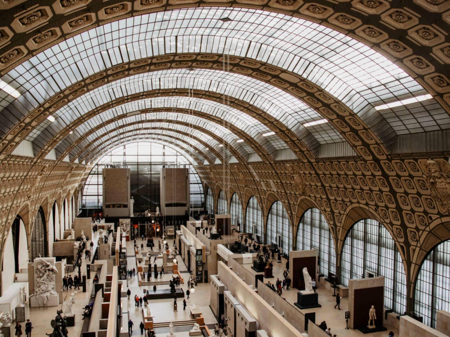 El museo Musée d'Orsay en París se encuentra en un antiguo edificio de estación de tren con techos altos y acristalados.