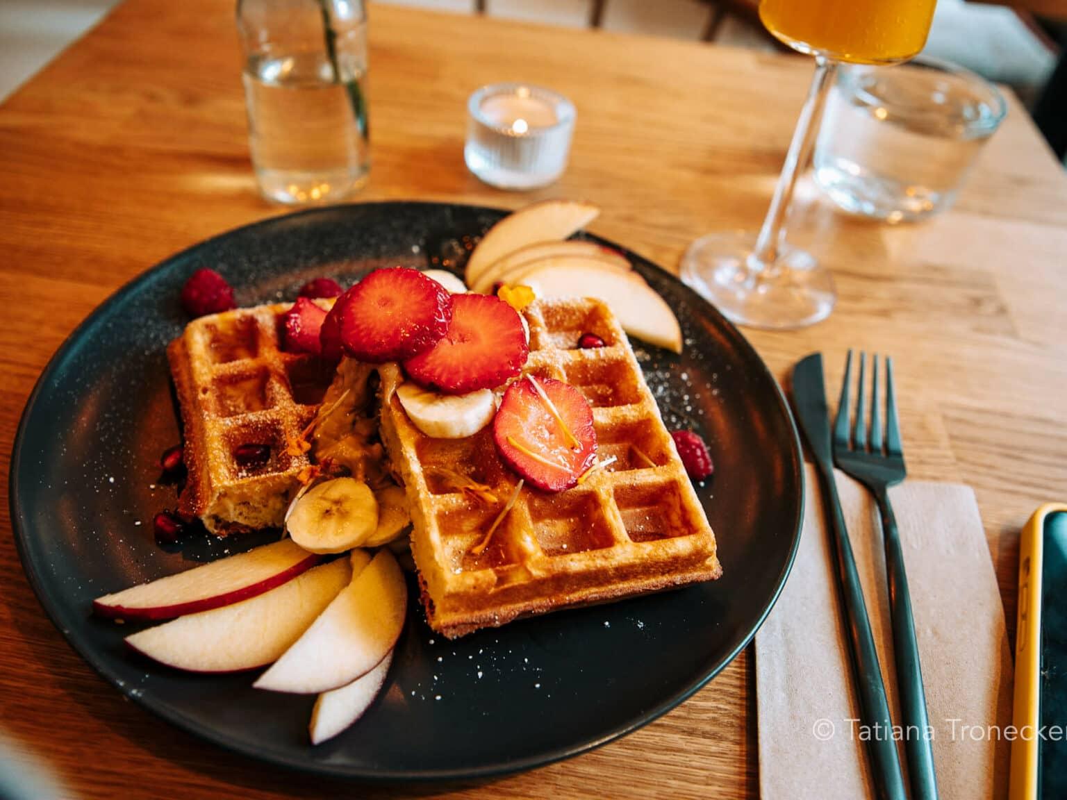 Two waffles with fruit on a plate at the Mimosa Brunch Club in Hamburg.