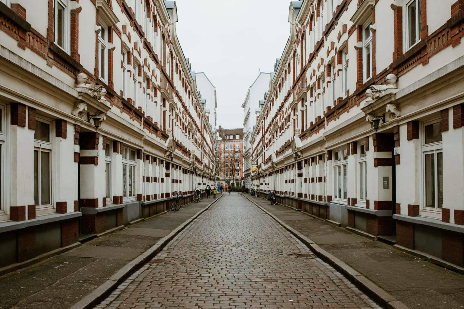 A small alley between two white brick houses in the Karolinenviertel in Hamburg.