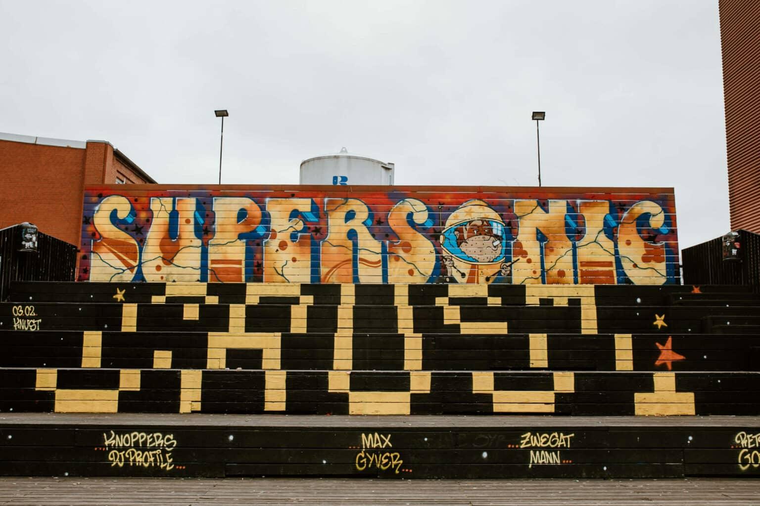 Black sprayed stairs lead to a large graffiti in the Schanzenviertel in Hamburg.