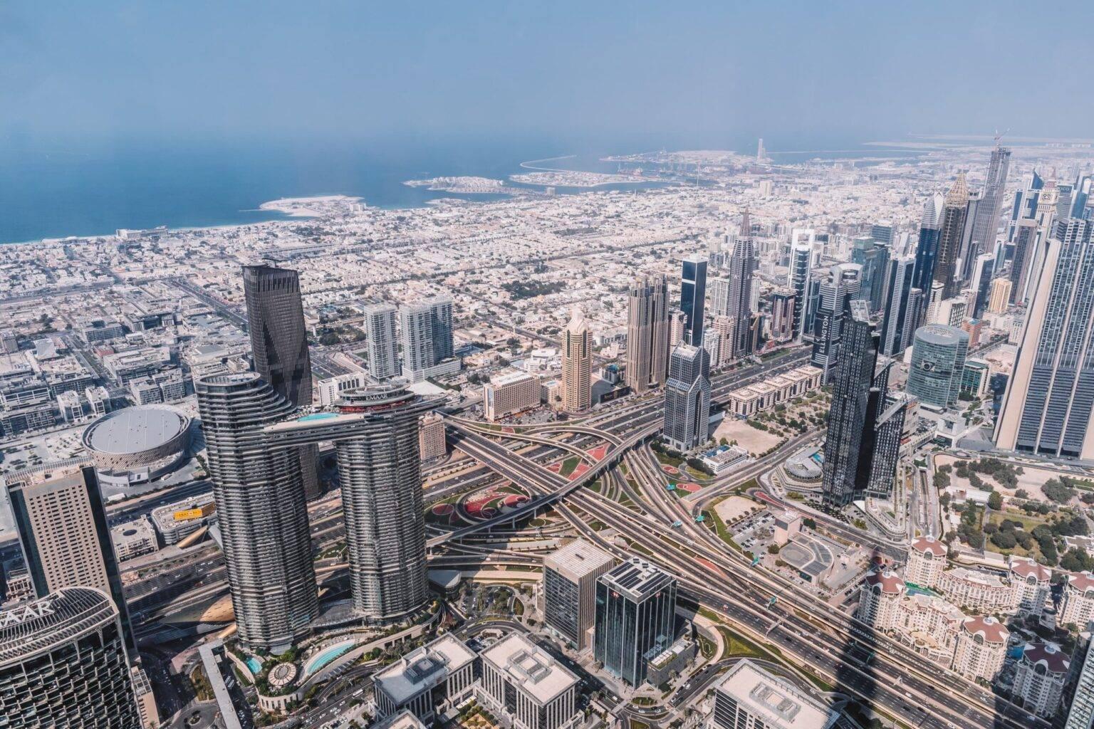 Dubai from a bird's eye view from the Burj Khalifa with the coast in the background.