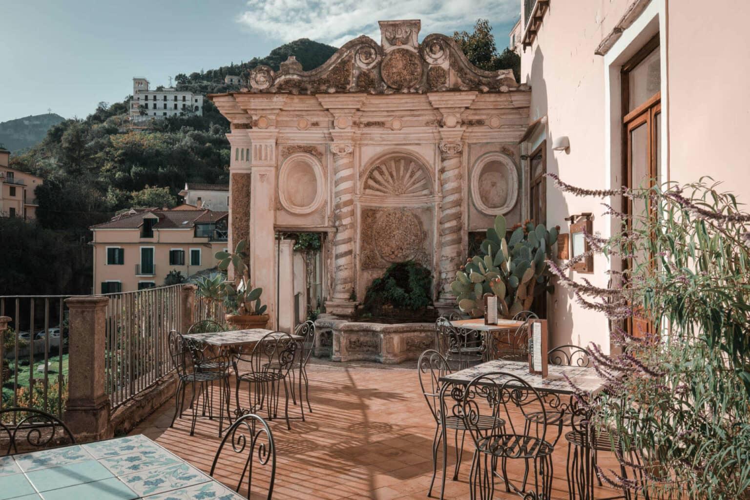A terrace with black chairs and tables.