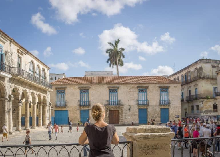 Una mujer mira hacia una fachada de casas en el centro de La Habana, Cuba, de espaldas a la cámara.