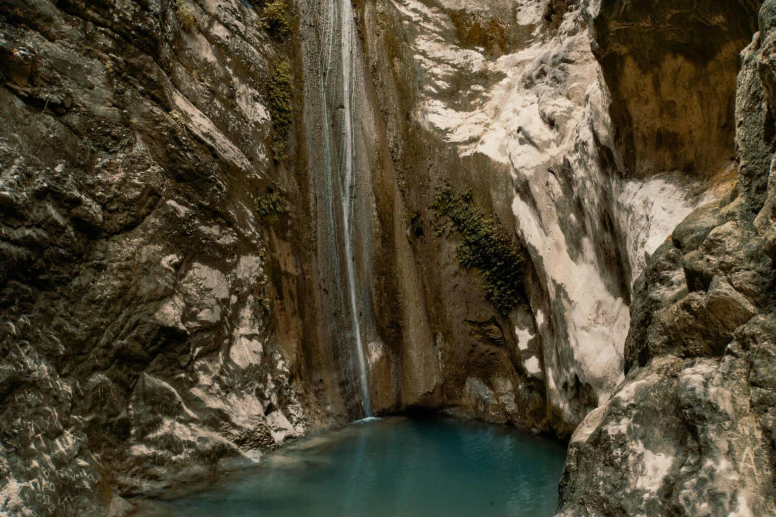A highlight for all visitors to the Greek island of Lefkada: The Dimosari Waterfall cascades down a steep mountain face into a pool filled with clear, turquoise water.