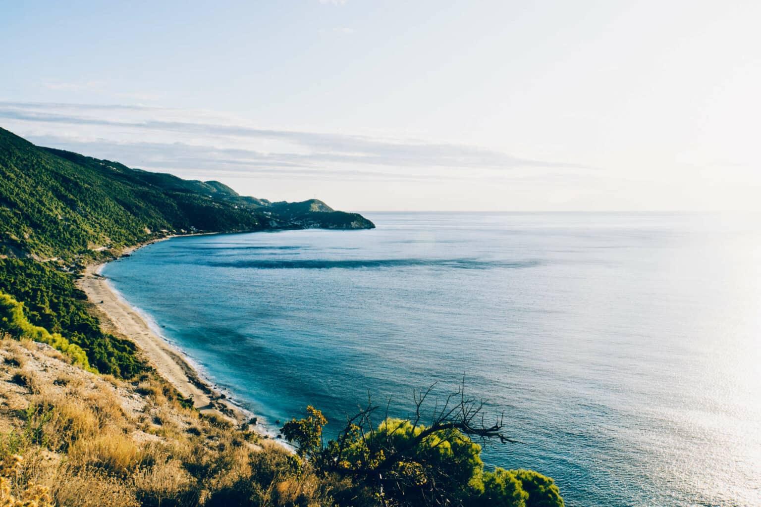 A bay on Lefkada with a sandy beach and turquoise sea surrounded by green hills - a dream for any vacationer.
