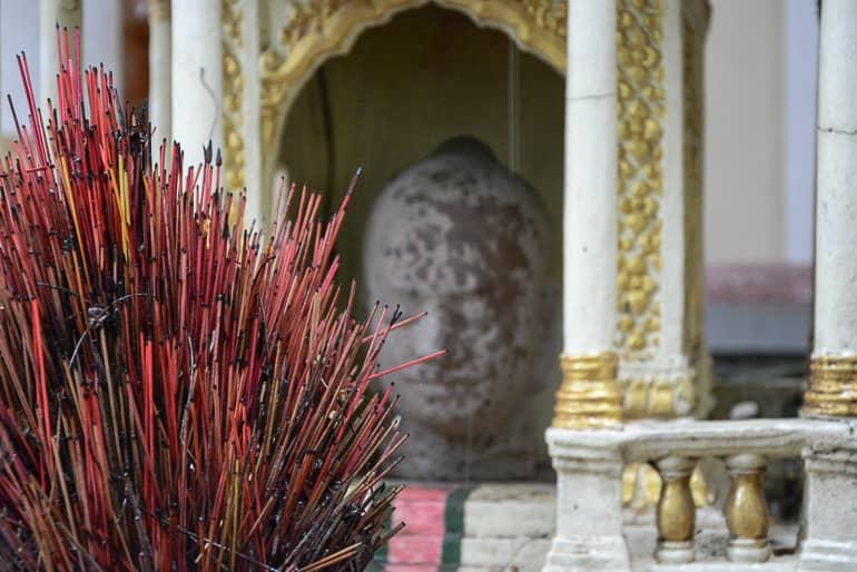 Wat Botum in Phnom Penh, Cambodia is located near the Royal Palace and houses a large stone Buddha statue between golden ornate arches.