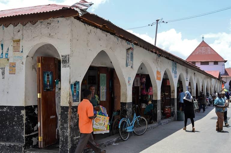 En el mercado Darajani de Stone Town, puedes comprar artículos de uso diario en tiendas que se esconden detrás de arcos de una larga fila de casas.