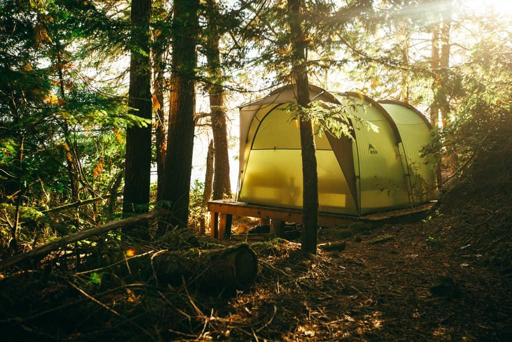 Vancouver Island: A large green tent stands in the woods under trees.