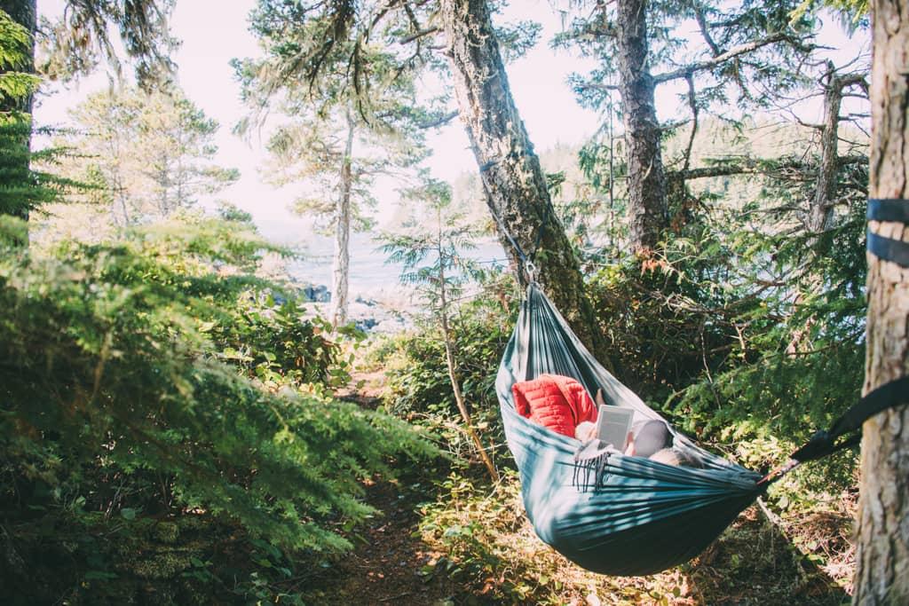 Isla de Vancouver: Una persona está en una hamaca, con un libro en la mano.
