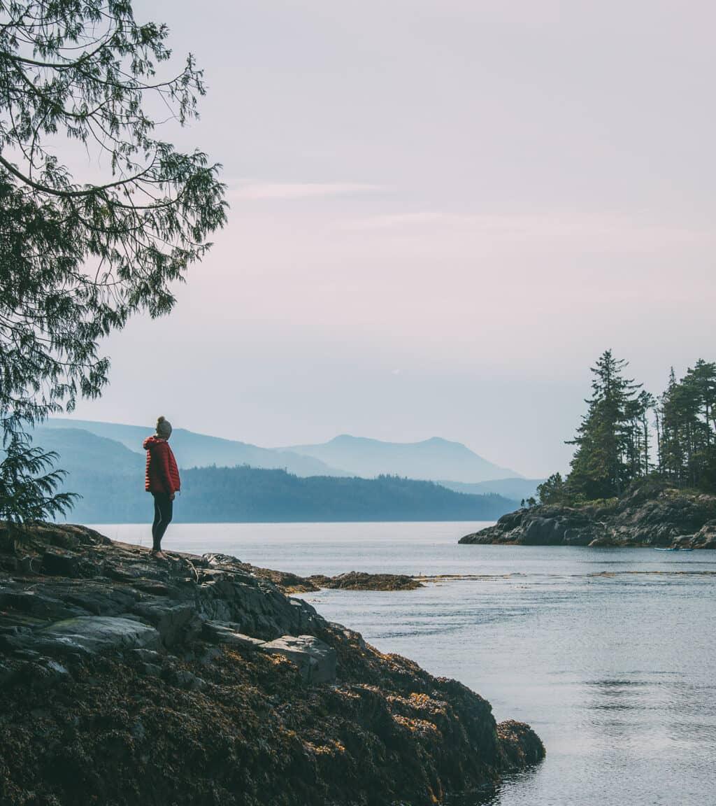 Isla de Vancouver: Una mujer está de pie sobre una roca con vista al mar.