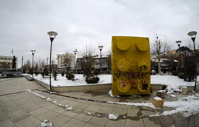 El símbolo con graffiti, un gran ladrillo de Lego amarillo, en Pristina, Kosovo, representa las seis regiones de Kosovo y debe representarse como la pieza faltante del rompecabezas o Lego de la UE.