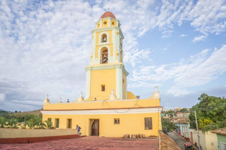 La torre amarilla de la iglesia Convento de San Francisco de Asis en Trinidad se eleva hacia el cielo cubano.