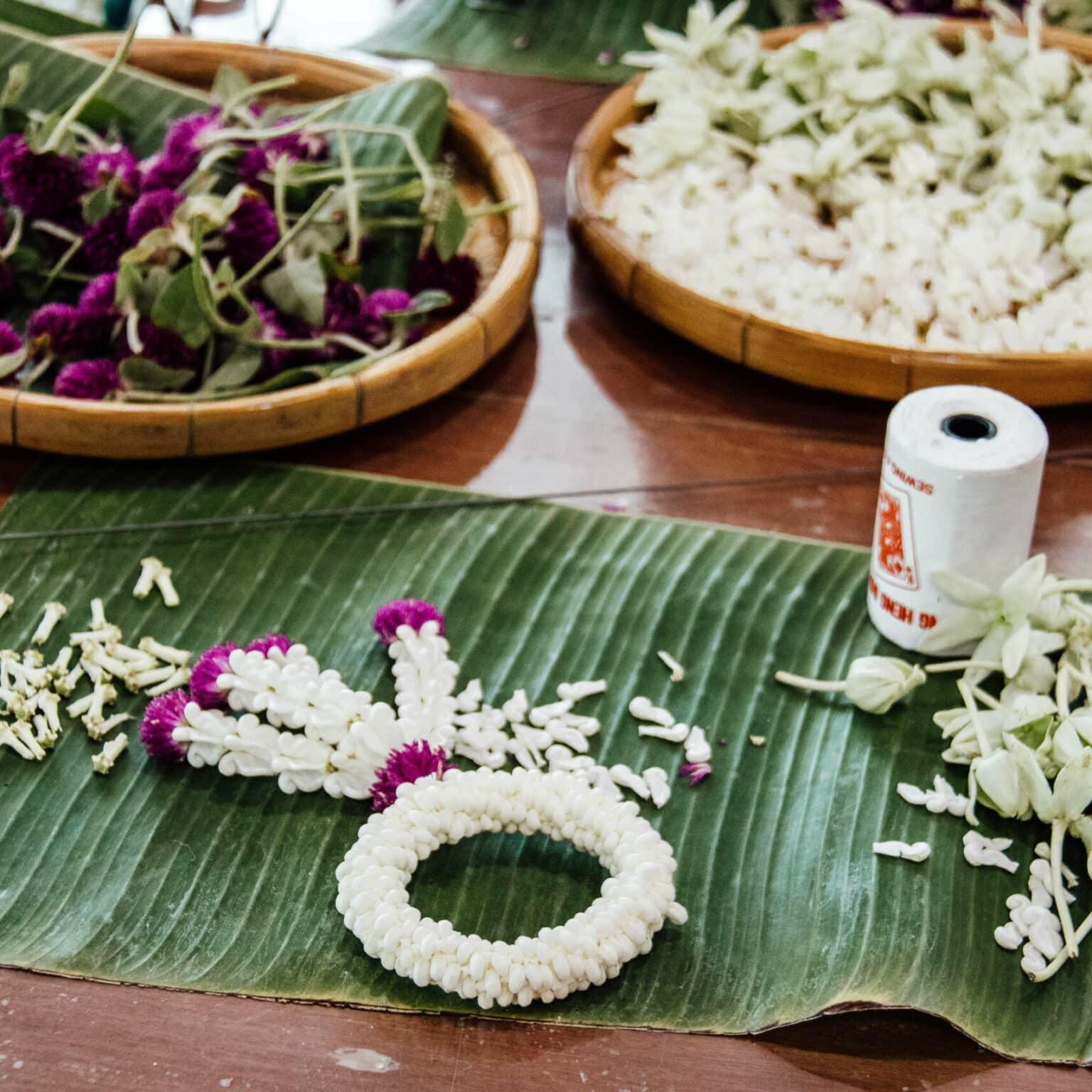 On a reed leaf lies a crafted work with white and pink flowers.