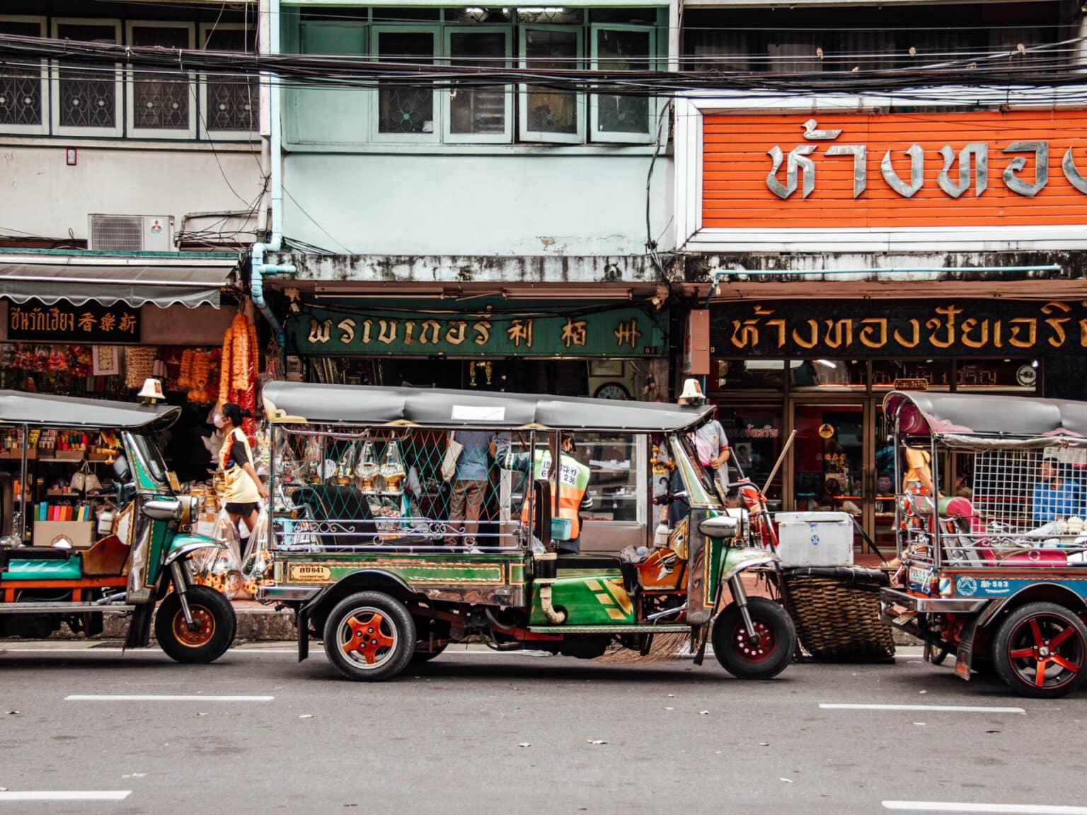 A fully loaded Tuk Tuk on a typical street in Bangkok.