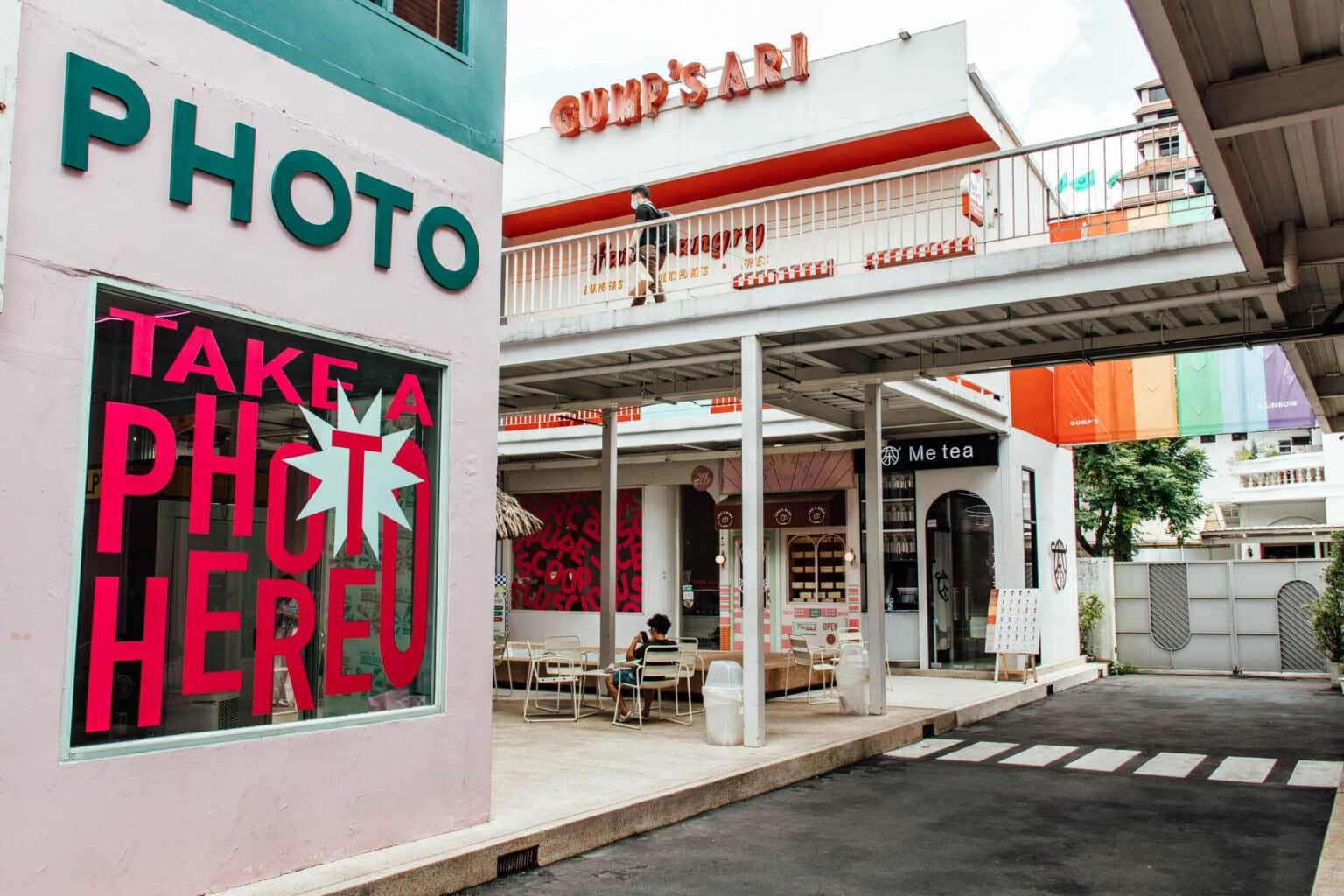 Buildings with white paint and red and turquoise lettering in the city of Bangkok.