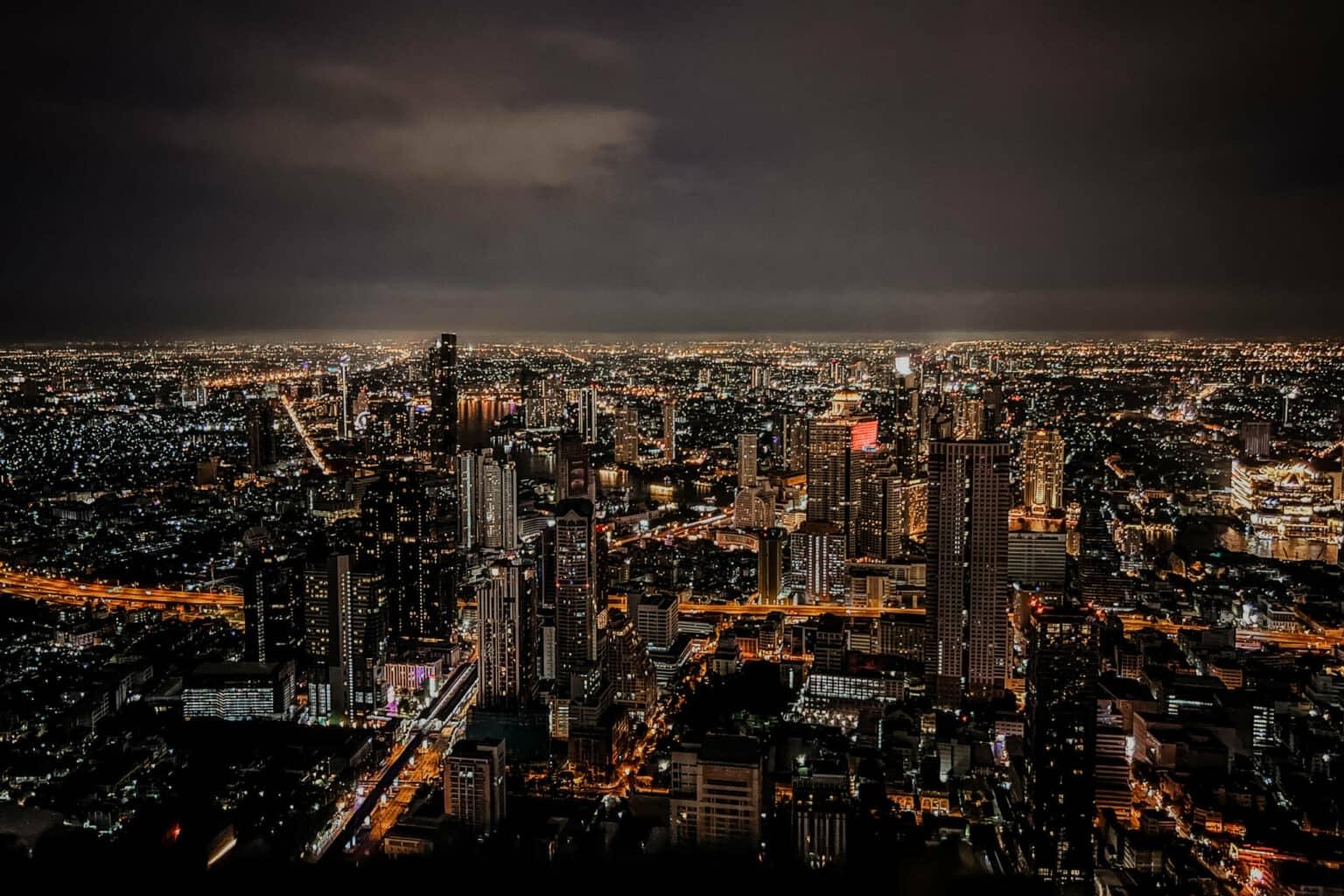 The brightly lit buildings and streets of Bangkok at night.
