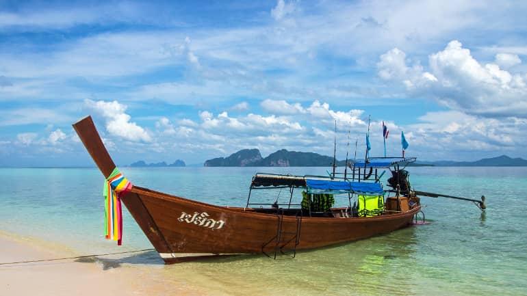 En la playa de Koh Kradan ha atraído a una longtail boat decorada con cintas y banderas de colores.