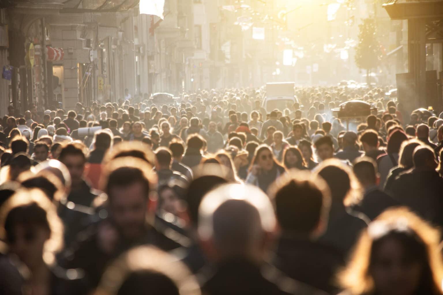 Cientos de personas corren a través de una calle extremadamente concurrida.