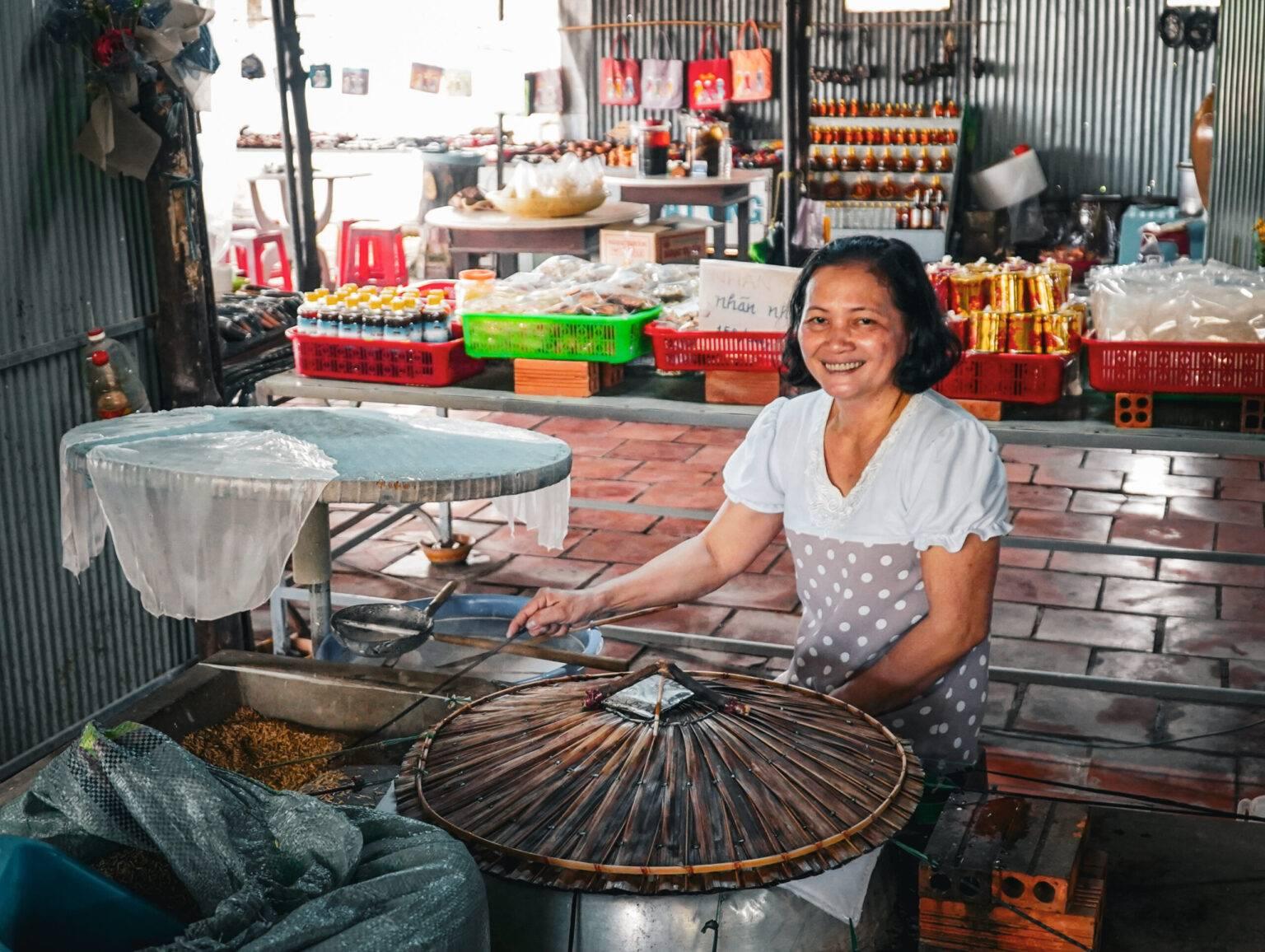 A woman producing rice noodles.